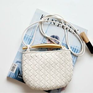 2 leather bags with sardine shaped metal handle. Colors black and white.